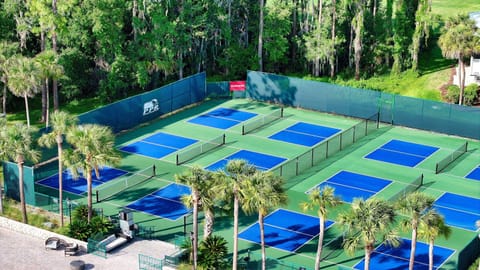 Challenge friends on multiple courts set amid lush greenery.