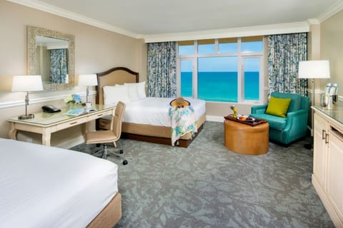 Settle into plush beds with calming sea-view backdrop.