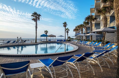 Dive into oceanfront bliss beside the sparkling palm-lined pool.