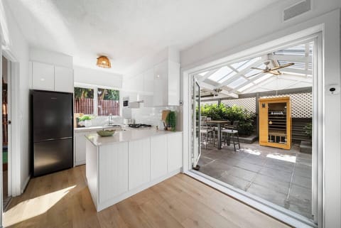 Cook with ease in the bright, well-equipped kitchen, featuring modern appliances, a Nespresso machine, and direct access to the courtyard for seamless indoor-outdoor living.