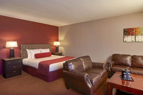 Unwind in a cozy king bed beside lounge seating.