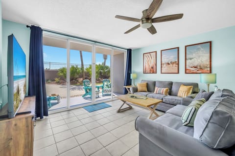 Relax in your spacious living room with ocean breezes from the ceiling fan and stunning patio views through floor-to-ceiling glass doors.