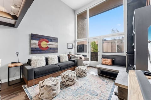 Sun-lit living room with sofa bed and smart TV