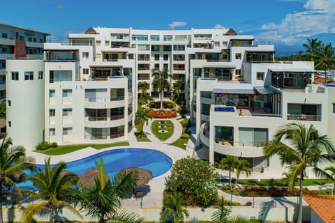 Elegant oceanfront resort with tropical pool, landscaped grounds, and upscale architecture.