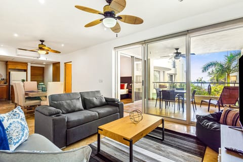 Relax in a spacious living area featuring comfortable seating, abundant natural light, and seamless access to the private balcony.