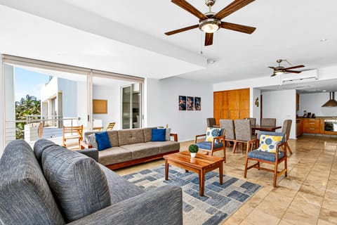 Bright and spacious open-concept living area featuring comfortable seating, natural light, and seamless indoor-outdoor flow. Perfect for relaxing, gathering, or enjoying quality time after a day at the beach.