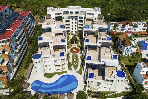 Resort-style condo complex with lush landscaping, large pool, and modern architecture perfectly located in the heart of Nuevo Vallarta near beaches, dining, and top attractions.