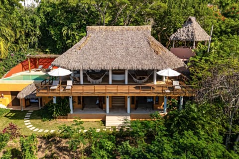 A bird's-eye view showcasing Casa Media Luna's stunning architecture, expansive outdoor spaces, infinity pool, and lush jungle surroundings.