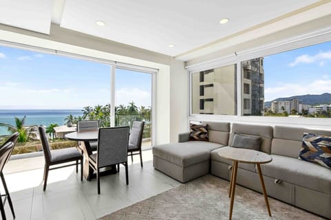Relax in a sun-filled living area featuring comfortable seating, modern décor, and stunning views of the Pacific Ocean.