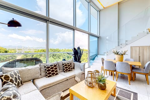 Floor-to-ceiling windows fill this stylish living area with natural light, creating the perfect space to relax, unwind, and enjoy the serene golf course surroundings.