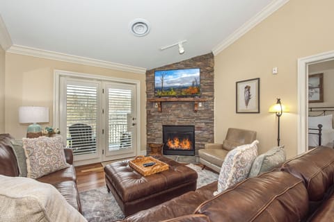 Curl up in this cozy living room where leather seating surrounds a crackling stone fireplace, perfect for your mountain getaway evenings.
