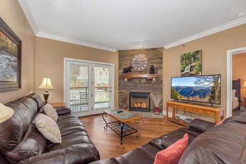 Cozy up by your stone fireplace while enjoying mountain views on the TV in this warmly appointed living room.