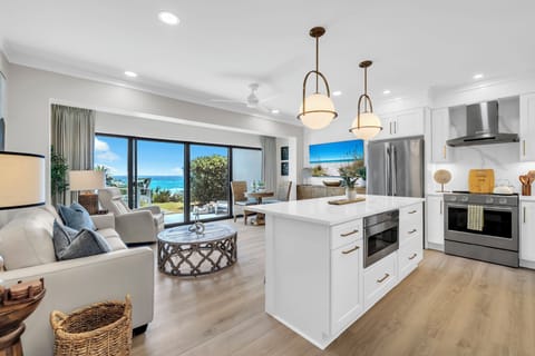Wake up to stunning ocean views from your modern kitchen and living space, where warm wood floors and coastal breezes create the perfect beachside retreat.