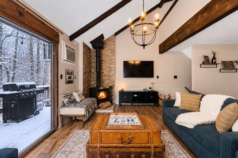 Relax in the living room with lots of natural light next to the cozy wood burning stove.