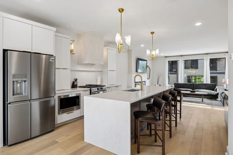 Kitchen: A spacious kitchen featuring a large island, bar stools, and pendant lights above.