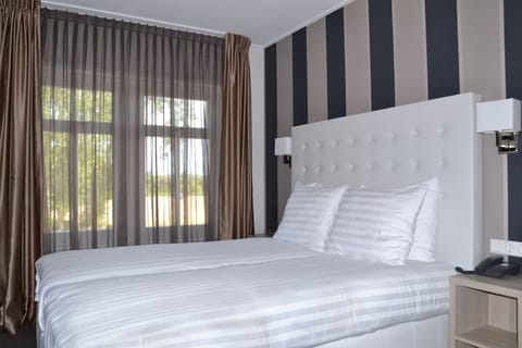 Unwind in crisp linens beside soothing daylight and views.