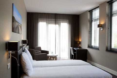 Step into a spacious retreat with beds, desk, and lounge seating.