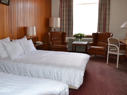 Relax into plush bedding in a warm, classic room.