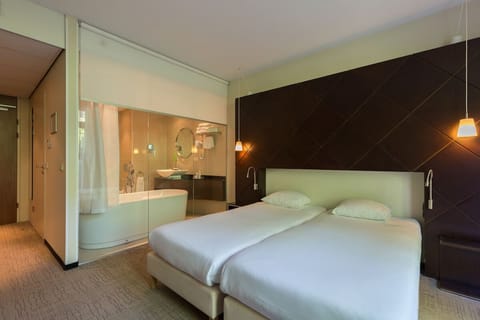 Unwind in crisp linens beside a spa-style soaking tub.