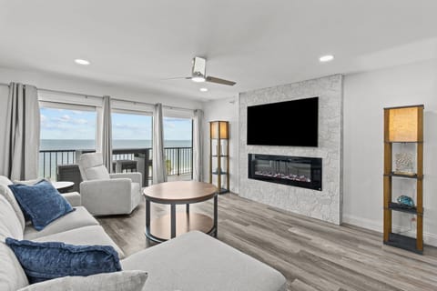 Living room view of Gulf, including electric fireplace and TV 