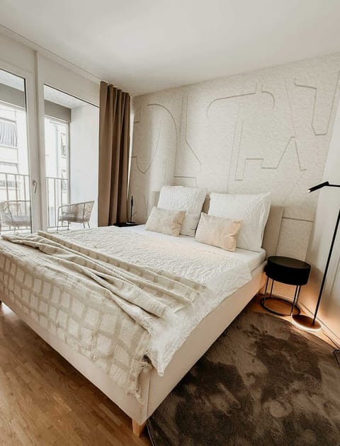 Schlafzimmer mit hochwertigem Boxspringbett, weicher Bettwäsche und stilvollen Textilien – für erholsamen Schlaf in ruhiger Atmosphäre. Zugang zum Balkon für frische Luft und einen entspannten Start in den Tag.