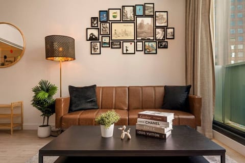 Relax into a warm, designer living space with a plush leather sofa and curated gallery wall.