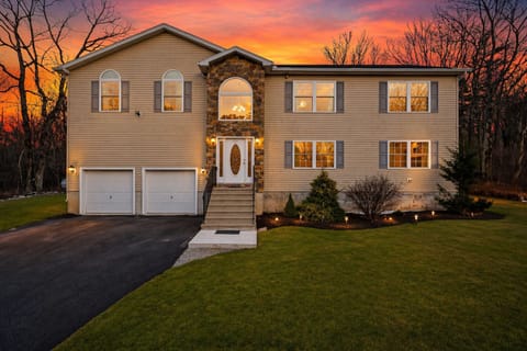 Warm sunset welcome—spacious mountain retreat with inviting curb appeal and room for everyone to gather.