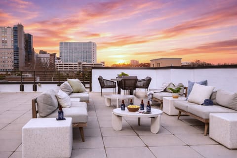 Shared rooftop lounge featuring white modern sectional seating and city views.