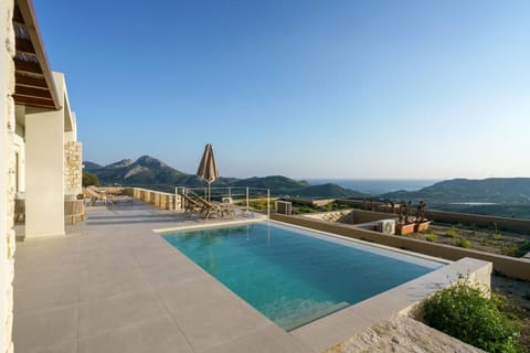 Modern pool with sunbeds and sea views, perfect for relaxing at any time of day.