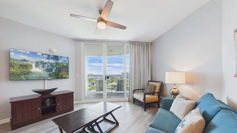 Living area with stylish furnishings and ample seating for TV + balcony access