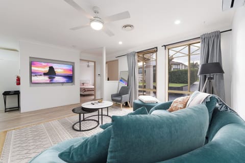 Bright modern lounge with large TV, comfy sectional, and outdoor access