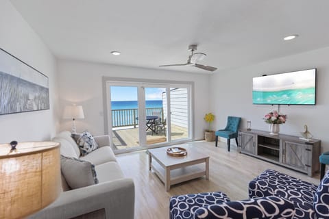 Relax in your bright, coastal living room with stunning ocean views from your private balcony—perfect for unwinding after a day at the beach.