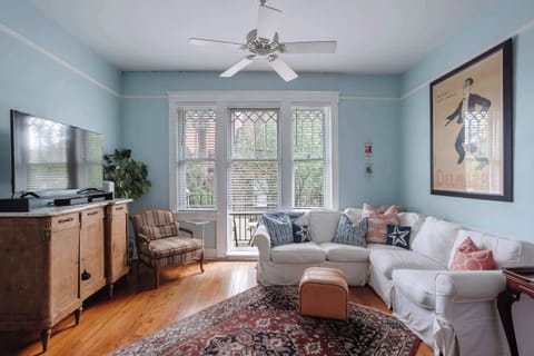 Spacious open-concept living area featuring comfortable seating, a large smart TV, fast Wi-Fi, and plenty of natural light!
