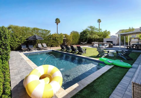 Private backyard with a pool, lounge seating, outdoor dining, and multiple spaces to relax. Designed for easy Scottsdale days spent swimming, gathering, and enjoying the sun.