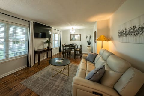 Comfortable living area with reclining sofas, TV, and dining table.