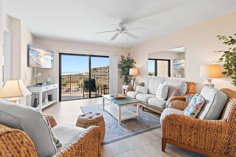 Bright & airy living room features sliding glass doors that lead to outdoor private oceanfront balcony