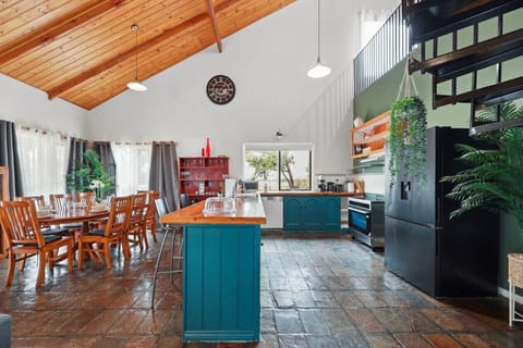 The kitchen and dining area`s warm, inviting charm invites you to gather for meals, especially with the timber dining table set beneath pendant lighting.