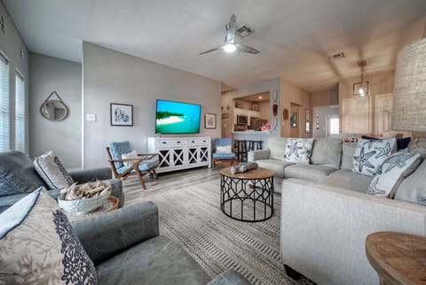 Coastal living room with comfy seating, beachy accents, and an easy flow into the kitchen.