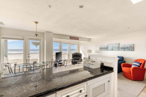 Oceanfront living with panoramic beach views, bright windows, and cozy seating—perfect for relaxing in style.