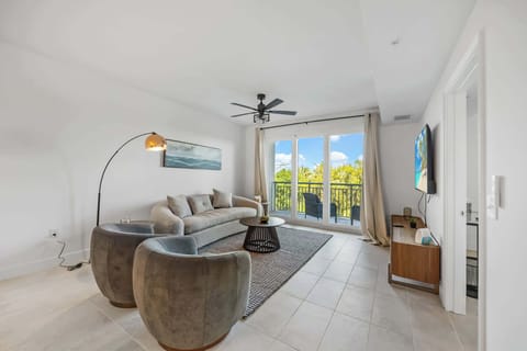 Modern living room with comfortable seating and balcony access overlooking greenery