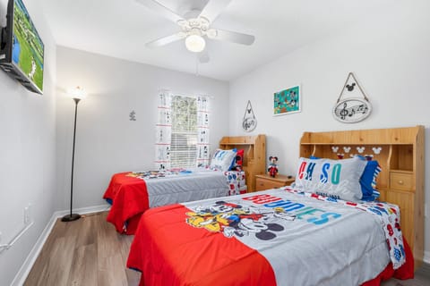 Comfortable Disney themed bedroom featuring two twin beds, ceiling fan, a flat-screen TV, high-speed Wi-Fi, and a welcoming space for kids, teens, or additional guests.