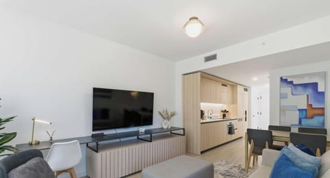 Modern open-concept living room with smart TV and city backdrop
