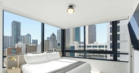 Sun-filled king bedroom with expansive city skyline views on the 14th floor
