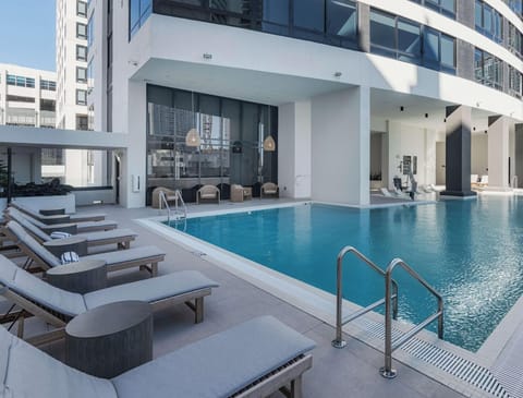 Gorgeous outdoor pool surrounded by modern architecture and plenty of space to soak up the sun