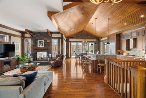 Lodge inspired open concept living with vaulted wood ceilings, stone fireplace & a full kitchen island. This is what 3,500 sq ft feels like.