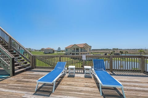 Soak up the sun on your private deck with comfortable blue loungers overlooking peaceful coastal scenery.