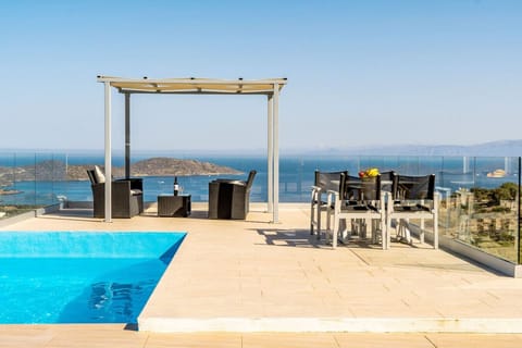 A serene outdoor space with views of the pool below and the sea beyond