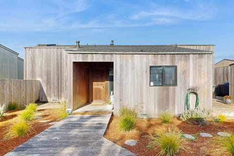 A wooden boardwalk lined with native grasses leads to the front door -- you'll feel the coastal calm before you even step inside.