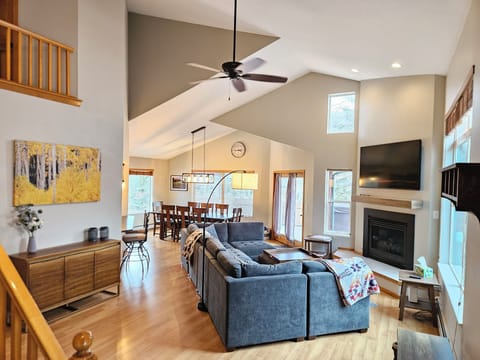 Comfortable living room with large TV, games, puzzles, and fireplace.