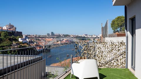 Imagine sipping your morning coffee or an evening glass of local wine on this vibrant terrace, soaking in the breathtaking panoramic views of the Douro River and the iconic D. Luís I Bridge. The comfortable outdoor seating and refreshing artificial turf c
